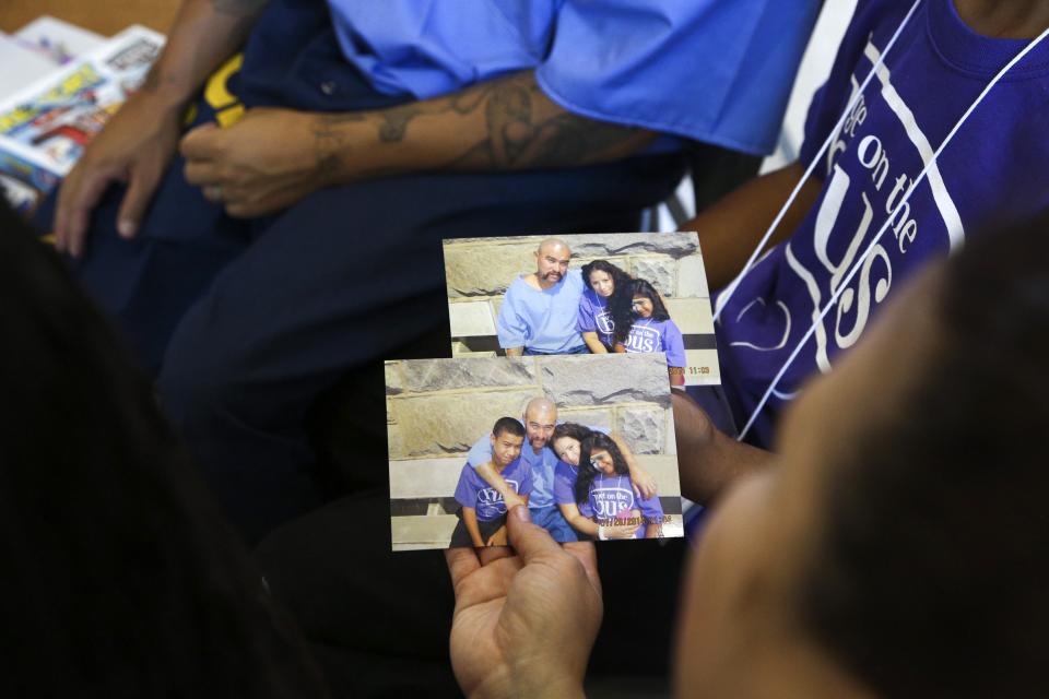 Iris Feliz looks at photos taken with her father Richard during a "Get On the Bus" visiting day to Folsom State Prison