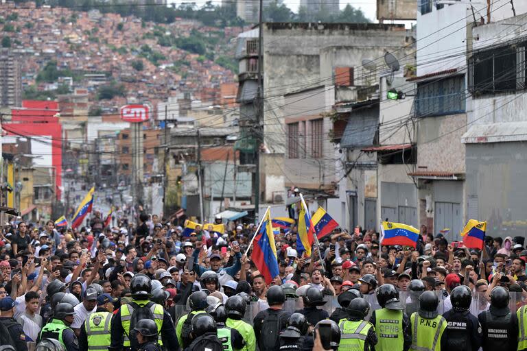 Opositores al gobierno del presidente venezolano Nicolás Maduro protestan frente a miembros de la Policía Nacional Bolivariana en el barrio Catia.