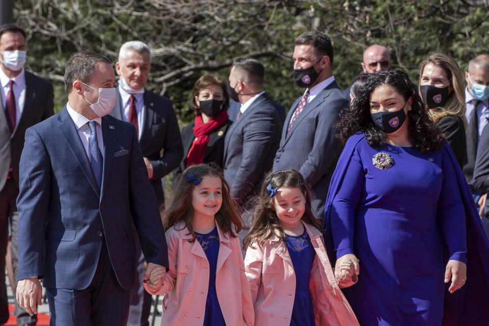 Kosovo newly elected president Vjosa Osmani Sadriu, with her husband Prindon Sadriu and their twin daughters Dua and Anda (left-right unknown), as they attend the presidential hand over ceremony in Pristina, Kosovo, on Tuesday, April 6, 2021. Osmani took over the presidency after being elected to the post during a two-day extraordinary session of parliament. (AP Photo/ Visar Kryeziu)