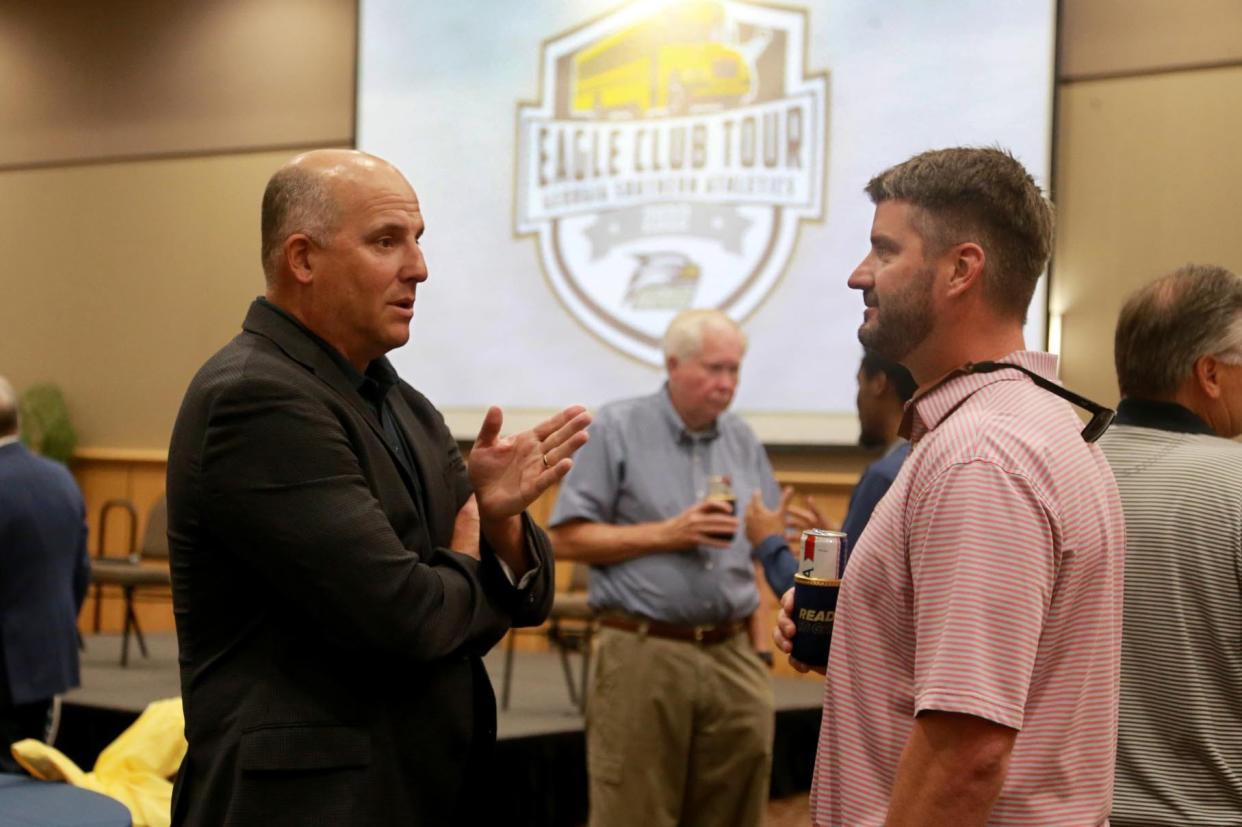 Georgia Southern head football coach Clay Helton, left, talks with Richmond Hill High School football coach Matt LeZotte at the Eagle Club Tour stop April 18 at the Armstrong Center in Savannah.