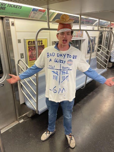 A New York Mets fan, who was escorted out of Citi Field after being hit by hot dogs, rode the subway with other supporters Tuesday in Queens. Photo by Brian Cushman/X