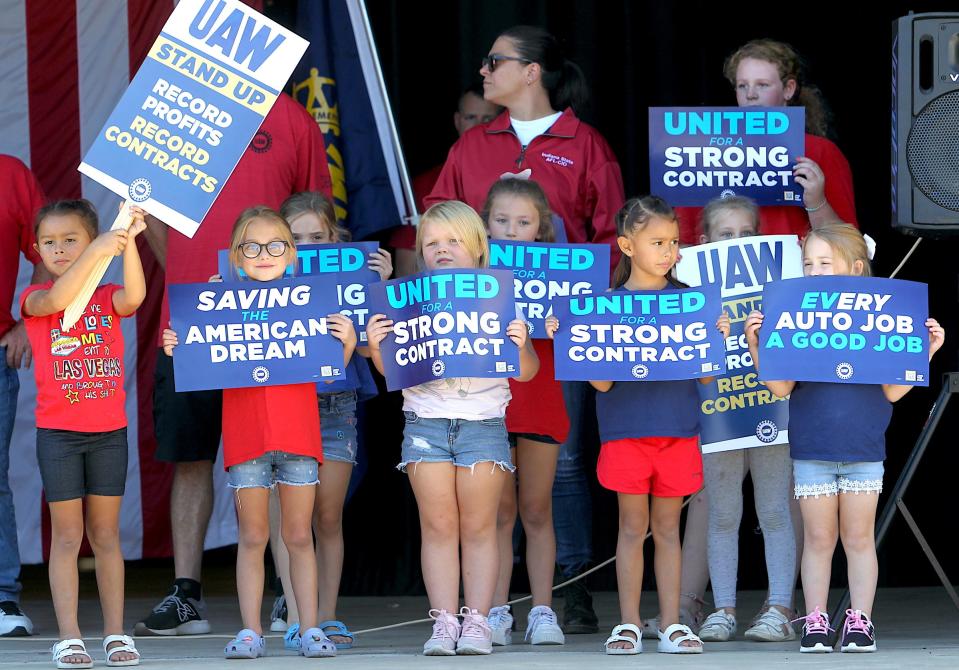 Youngsters take the stage with signs at a gathering of UAW 440 members in Harp Commons Sunday, Sept. 24, 2023.