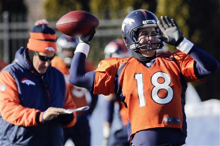 Denver Broncos offensive coordinator Adam Gase (L) checks his clipboard as quarterback Peyton Manning (18) throws a pass during their practice session for the Super Bowl at the New York Jets Training Center in Florham Park, New Jersey, January 29, 2014. REUTERS/Ray Stubblebine