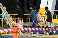 Migrants embark a ferry to the mainland, in Lampedusa