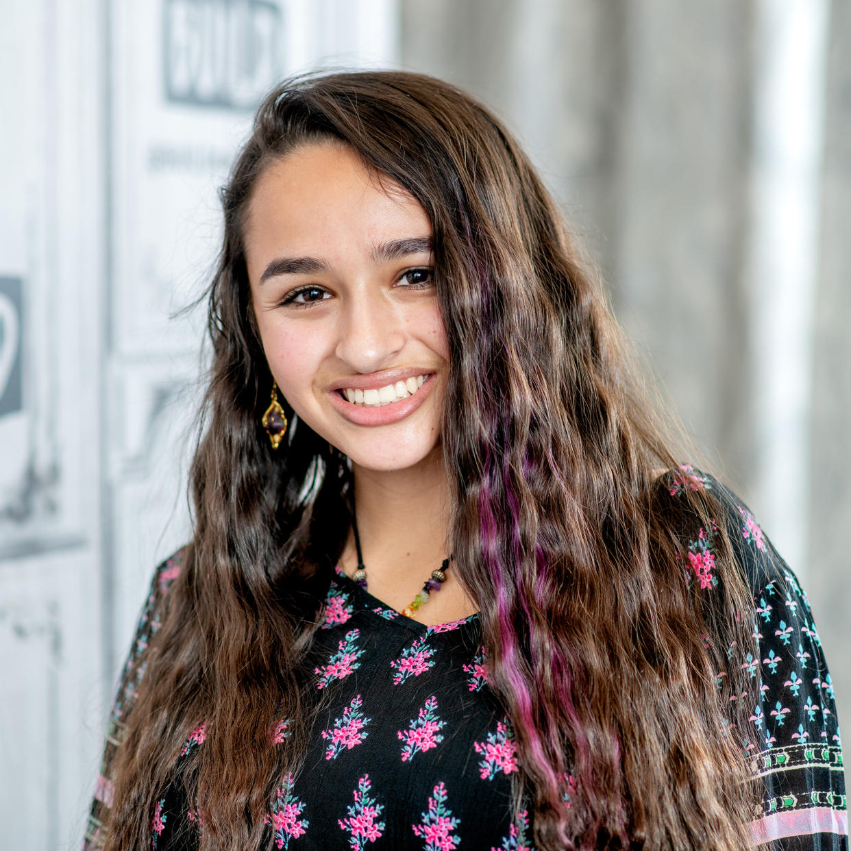 Jazz Jennings with a few streaks of purple in her hair smiles is a close up photo with a white background (Roy Rochlin / Getty Images)