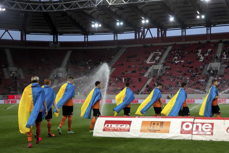 Los jugadores de Shakhtar Donetsk salen a la cancha con la bandera de su país, Ucrania; de los 14 extranjeros que había en el plantel apenas quedó uno desde que estalló el conflicto con Rusia