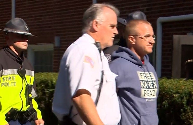 Aidan Kearney, better known as blogger "Turtleboy," right, is escorted by authorities after his arrest on witness intimidation charges Wednesday, Oct. 11, 2023.