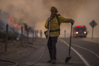 <p>A firefighter holds a hose on the 120 freeway during the La Tuna fire on Sept. 2, 2017 near Burbank, Calif. (Photo: David McNew/Getty Images) </p>