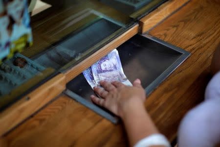 A woman exchanges English Pound notes for Euros notes at a money exchange office in the British overseas territory of Gibraltar, historically claimed by Spain, June 24, 2016, after Britain voted to leave the European Union in the EU BREXIT referendum. REUTERS/Jon Nazca