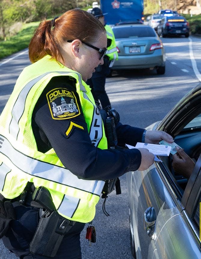 An Athens-Clarke police officer checks a driver's license on Tuesday.