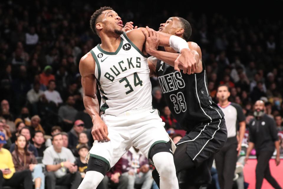 Bucks forward Giannis Antetokounmpo and Nets center Nic Claxton battle for position in the lane during the second quarter Thursday.