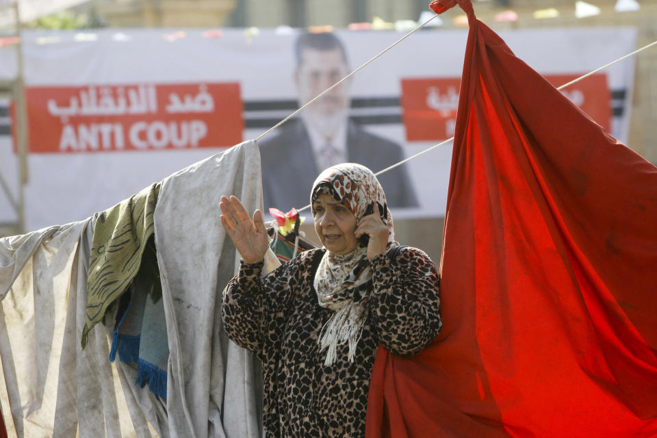 A supporter of Egypt's ousted President Mohammed Morsi, seen in the poster, talks on her mobile in front of Cairo University, where protesters have installed their camp in Giza, southwest of Cairo, Egypt, Thursday, Aug. 1, 2013. (AP Photo/Amr Nabil)