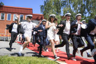 Students run celebrating their high school graduation at Nacka Gymnasium in Stockholm, Sweden, on Wednesday June 3, 2020. After being subject to distance teaching since March due to the coronavirus, students got their grades at school, though only two relatives were allowed per student to receive them outside. (Jessica Gow / TT via AP)