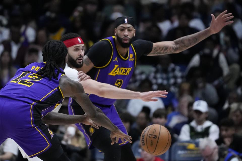 Pelicans forward Larry Nance Jr. tries to block a pass between Lakers forward Taurean Prince and forward Anthony Davis.