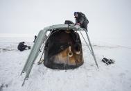 Engineers document cargo as it is unloaded from the Soyuz TMA-10M spacecraft after it landed with former ISS commander Oleg Kotov and flight engineers Sergei Ryazansky and Michael Hopkins from NASA onboard in a remote area southeast of the town of Zhezkazgan in central Kazakhstan, March 11, 2014. (REUTERS/Bill Ingalls/NASA/Handout via Reuters)