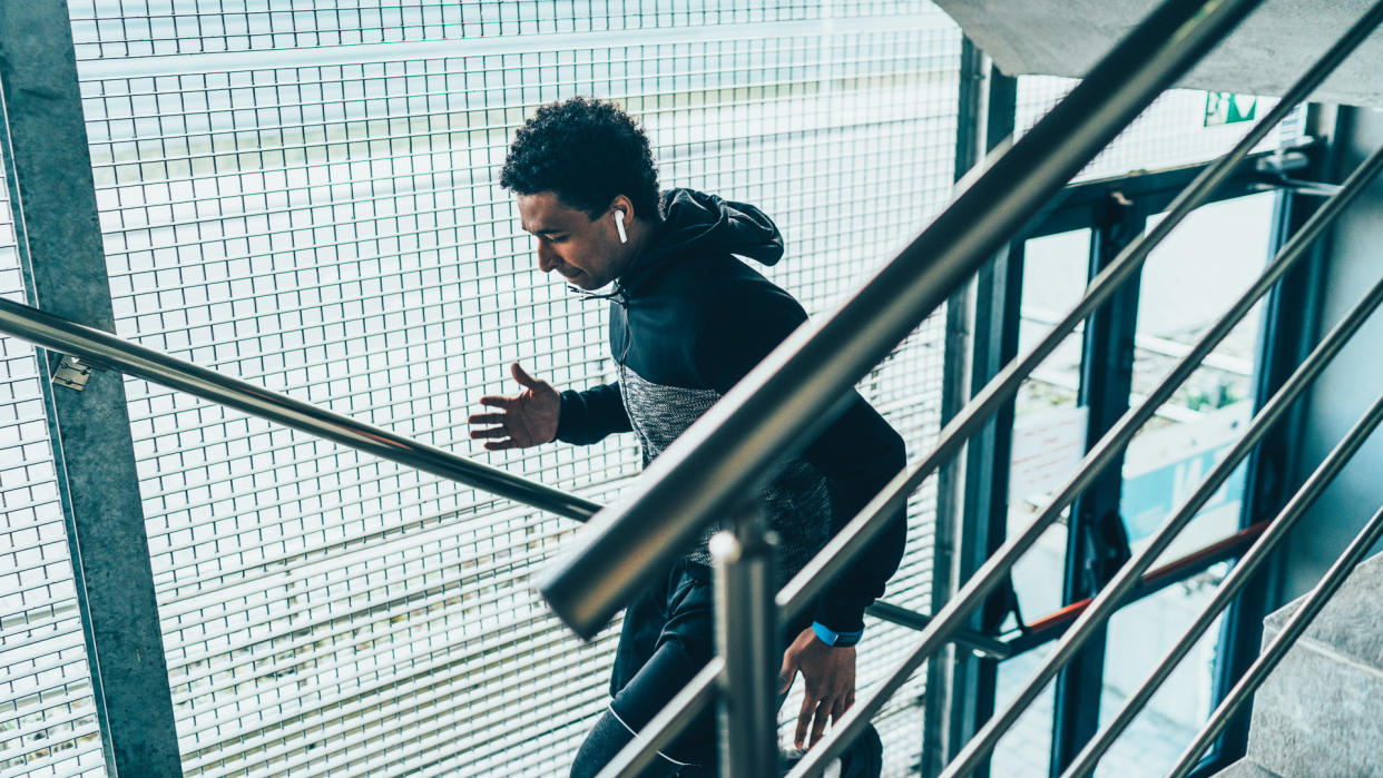 Afro-american sportsman running in the city.