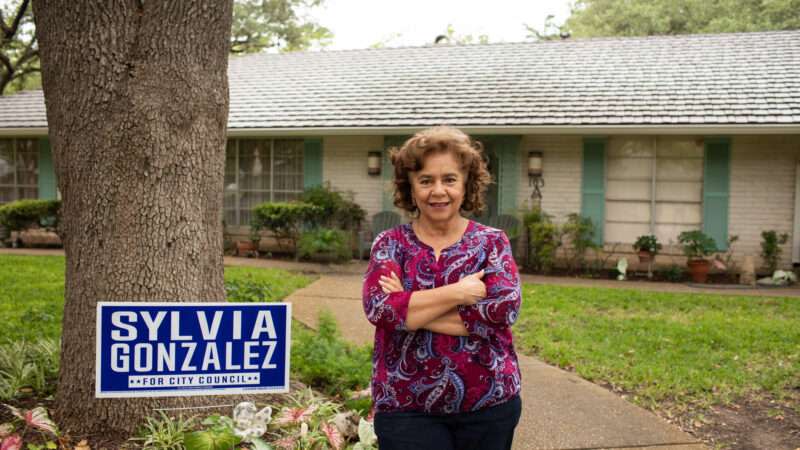 Sylvia Gonzalez stands in her front yard next to one of her city council campaign sign