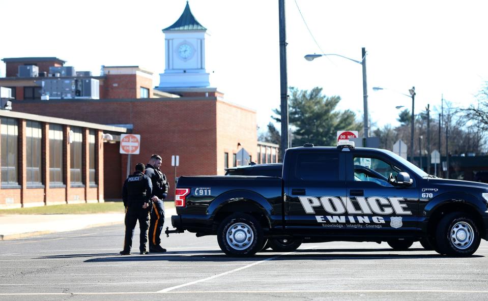 Ewing Township police officers stand watch outside the Ewing Township High School on Parkway Avenue Tuesday afternoon, February 14, 2023.  Classes were canceled here after investigators learned of a potential threat from a mass-shooting suspect in Michigan.