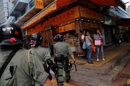 Riot police search for anti-government protesters in Tsuen Wan, near the site where police shot a protester with live ammunition on China's National Day in Hong Kong