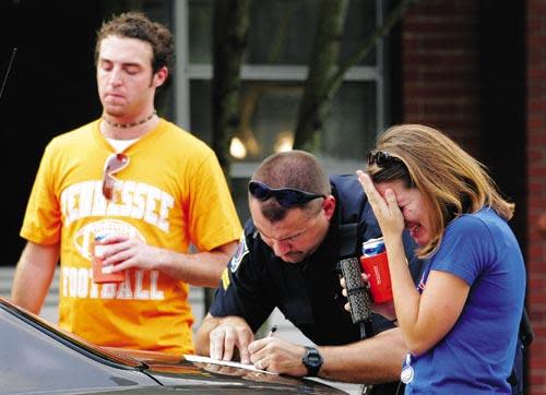 Visitors from Knoxville, Tennesee become visibly upset as a Gainesville police officer writes up an arrest report at the corner of Northwest First Avenue and 18th Street in downtown Gainesville. The pair were in town to attend the University of Florida-University of Tennessee football game but were charged for violating Gainesville’s open container ordinance by walking down University Avenue with open cans of beer.