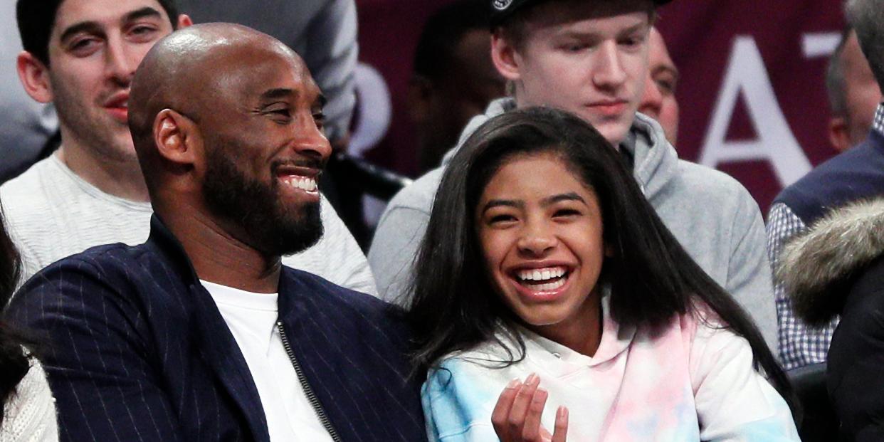 Gianna Bryant and Kobe Bryant watch a basketball game.