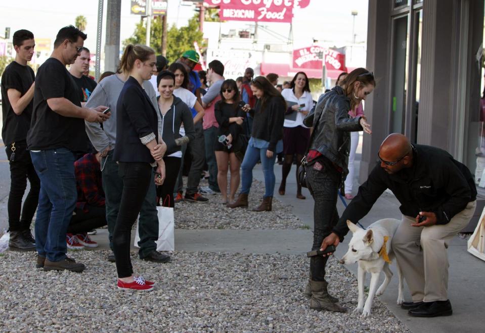 A visitor to the Stephen Cohen Gallery is searched by security prior to entering the gallery for an exhibition called "#IAMSORRY," by actor Shia LaBeouf in Los Angeles on Wednesday, Feb. 12, 2014. Seated at a small table, wearing a disheveled tuxedo and the paper bag with some eye holes cut out and the words "I AM NOT FAMOUS ANYMORE" scrawled in black ink across it, LaBeouf began his planned seven-hour, seven-day stint inside the small gallery on Tuesday, Feb. 11, 2014. (AP Photo/Richard Vogel)