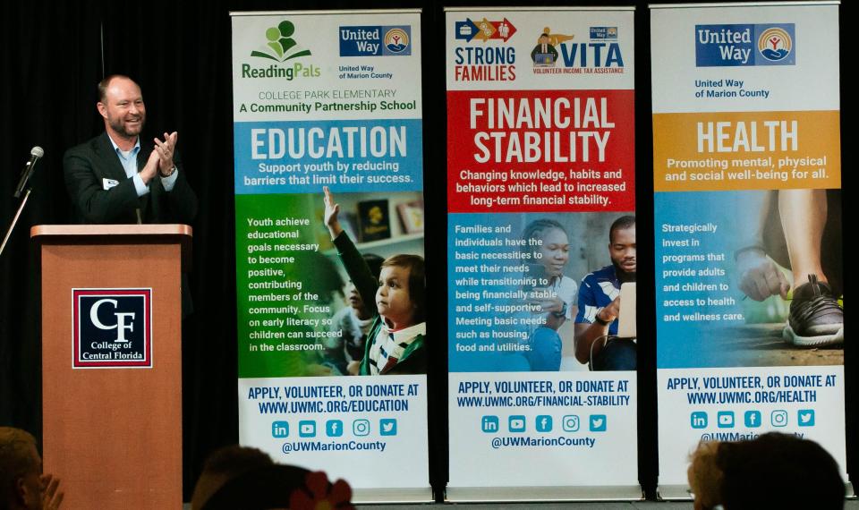 United Way of Marion County Board Chair Greg Harrell, who is also the Marion County clerk of court and comptroller, claps at the accomplishment of the organization after a brief video Thursday evening at UWMC's 2021 Community Celebration at the College of Central Florida's Klein Center.