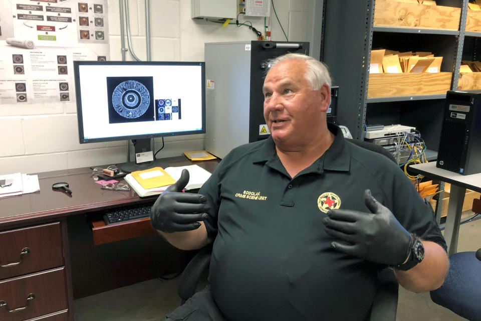 In this Monday, July 1, 2019 photo, Fort Bend County Sheriff's Office crime scene investigator Dominic Sodolak discusses a federal ballistics database his agency uses to help it generate leads in unsolved shootings, in his Richmond, Texas office. “Finding a casing for us, I look at it as better than finding a fingerprint,” said Sodolak. (AP Photo/Juan Lozano)