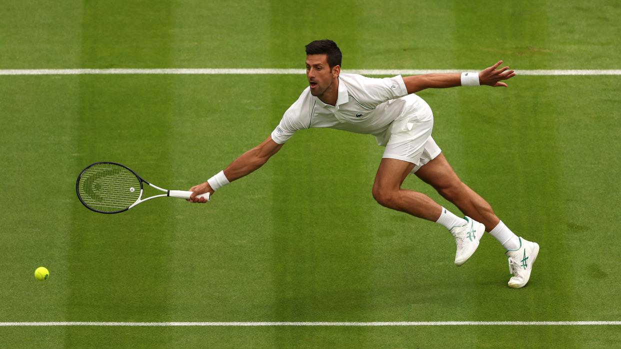  Novak Djokovic of Serbia stretches for the ball in the Men's Singles at The Wimbledon Championships. 