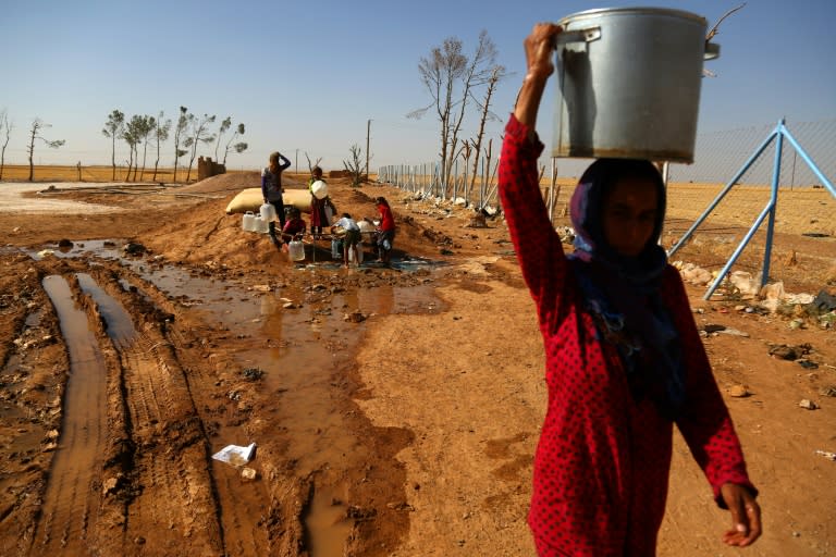 A displaced Syrian woman walks on June 9, 2017 at the al-Mabrouka camp in the village of Ras al-Ain on the Syria-Turkey border, where many Syrians who fled from territory held by the Islamic State group in Raqa are taking shelter