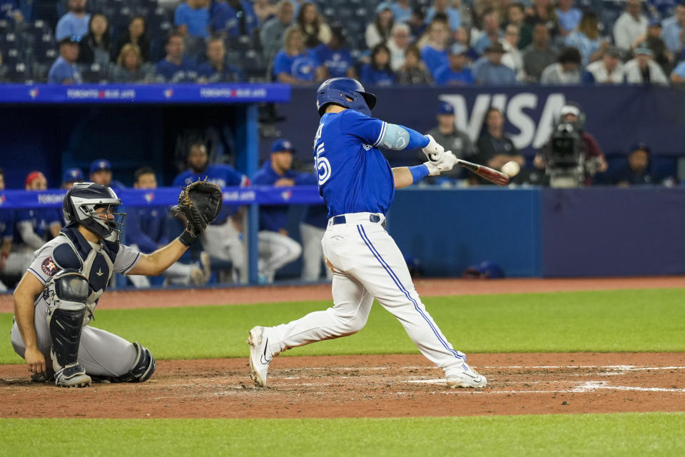 Toronto Blue Jays' Daulton Varsho, right, hits a home run against the Houston Astros in eighth-inning baseball game action in Toronto, Ontario, Monday, June 5, 2023. (Andrew Lahodynskyj/The Canadian Press via AP)