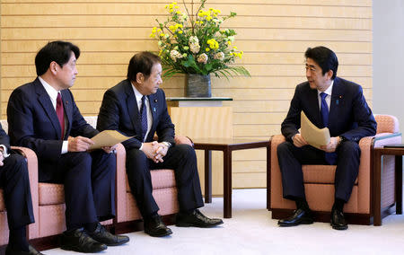 Japanese Prime Minister Shinzo Abe (R) speaks to Hiroshi Imazu (C), Chairman of Research Commission on Security of Japan's ruling Liberal Democratic Party (LDP), and former Defense Minister Itsunori Onodera (L), head of LDP panel on security policy, after a proposal on missile defense was submitted to Abe at the prime minister's office in Tokyo, Japan March 30, 2017. REUTERS/Eugene Hoshiko/Pool