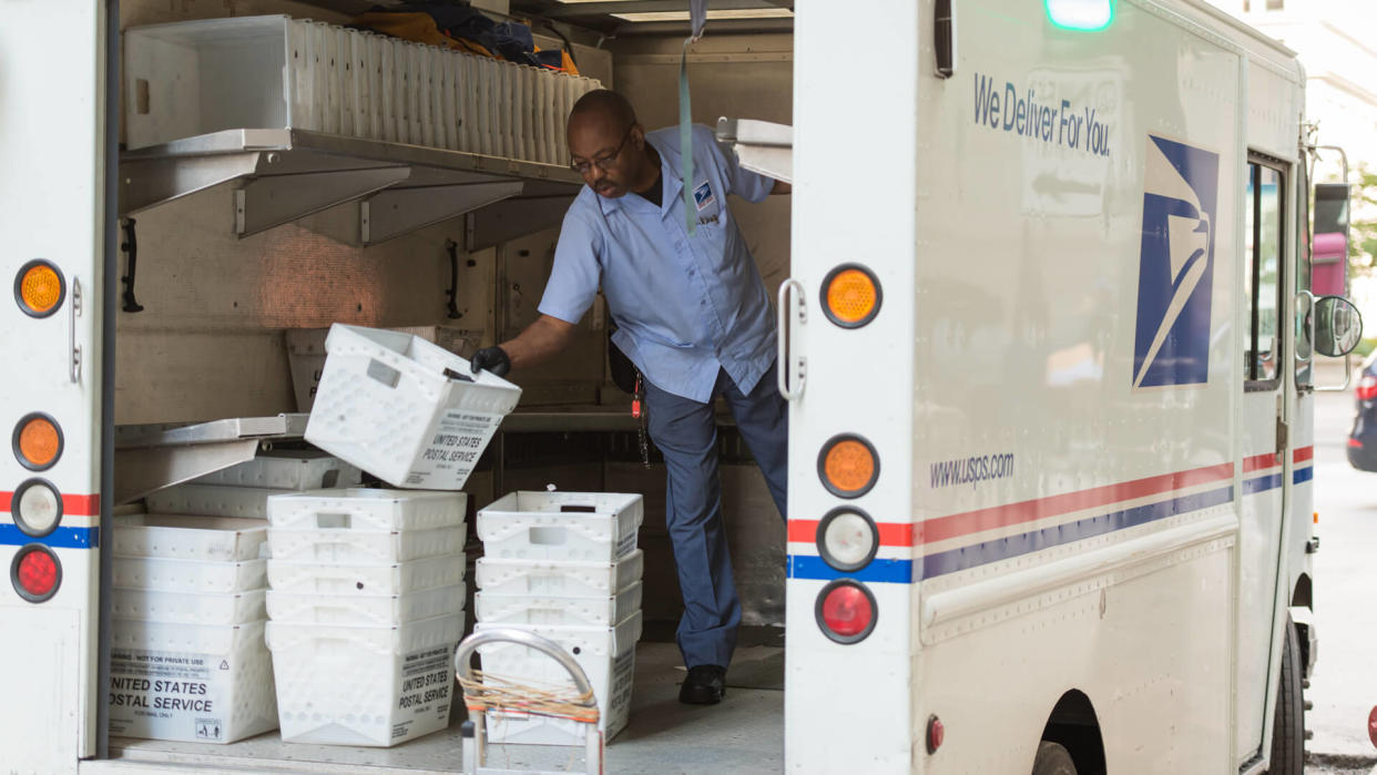 Chicago, USA - September 10, 2015: A USPS deliveryman sorting in the back of his truck on LaSalle street in the Loop late in the day.