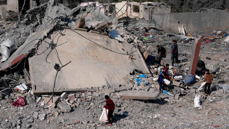 PHOTO: Palestinians salvage belongings from the rubble of a building of the Hamad family destroyed in an Israeli strike in Deir al Balah, Gaza Strip, Dec. 29, 2023.  (Adel Hana/AP)