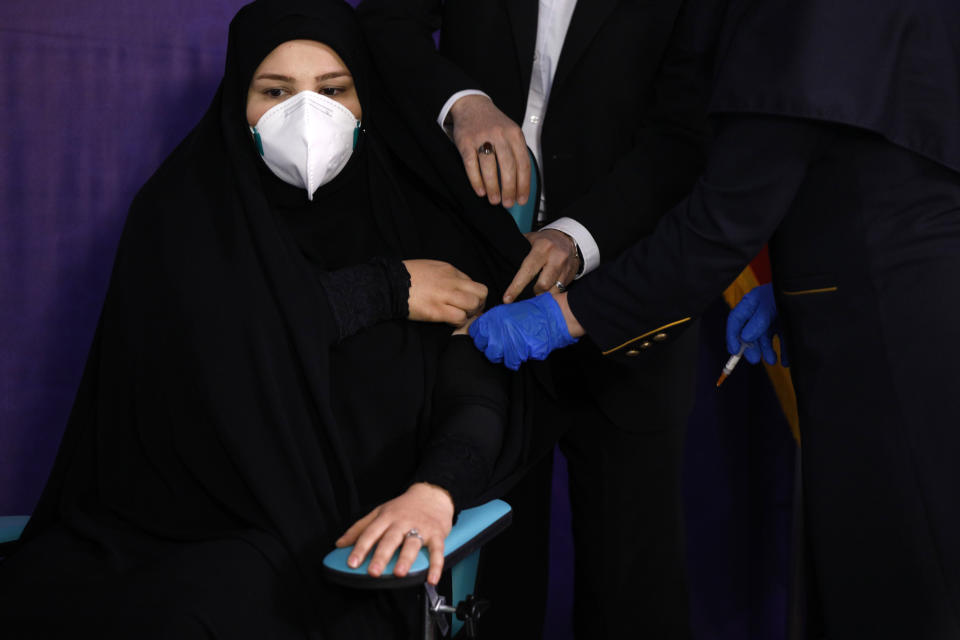 Tayebeh Mokhber is injected with the Coviran coronavirus vaccine produced by Shifa Pharmed, part of a state-owned pharmaceutical conglomerate, in a ceremony in Tehran, Iran, Tuesday, Dec. 29, 2020. The first study of the safety and effectiveness of the coronavirus vaccine in Iran began Tuesday, state TV reported, with dozens due to receive the domestically developed shot in the hardest-hit country in the Middle East. (AP Photo/Aref Taherkenareh)