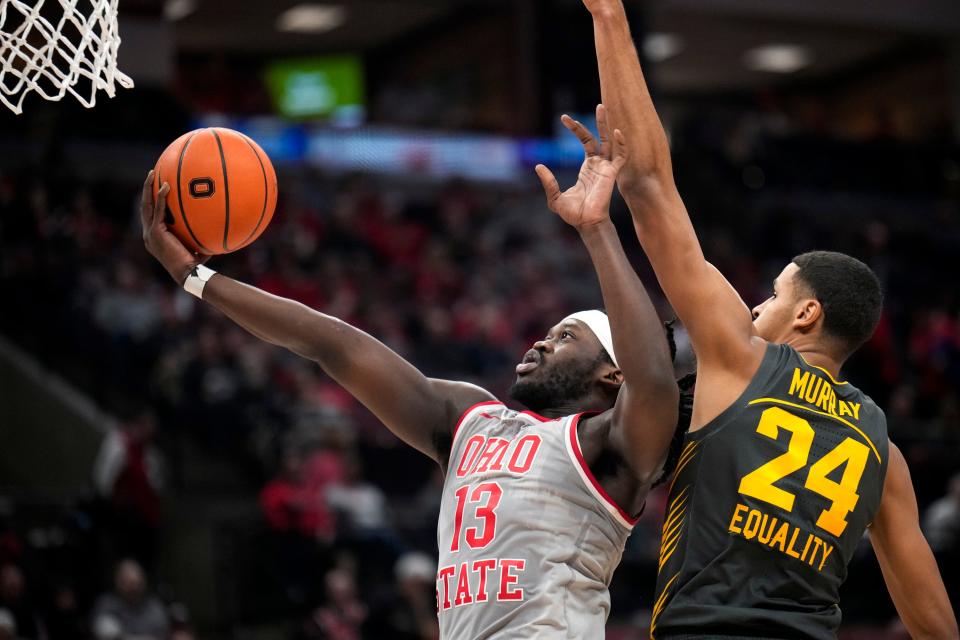 Ohio State's Isaac Likekele scores while defended by Iowa's Kris Murray.
