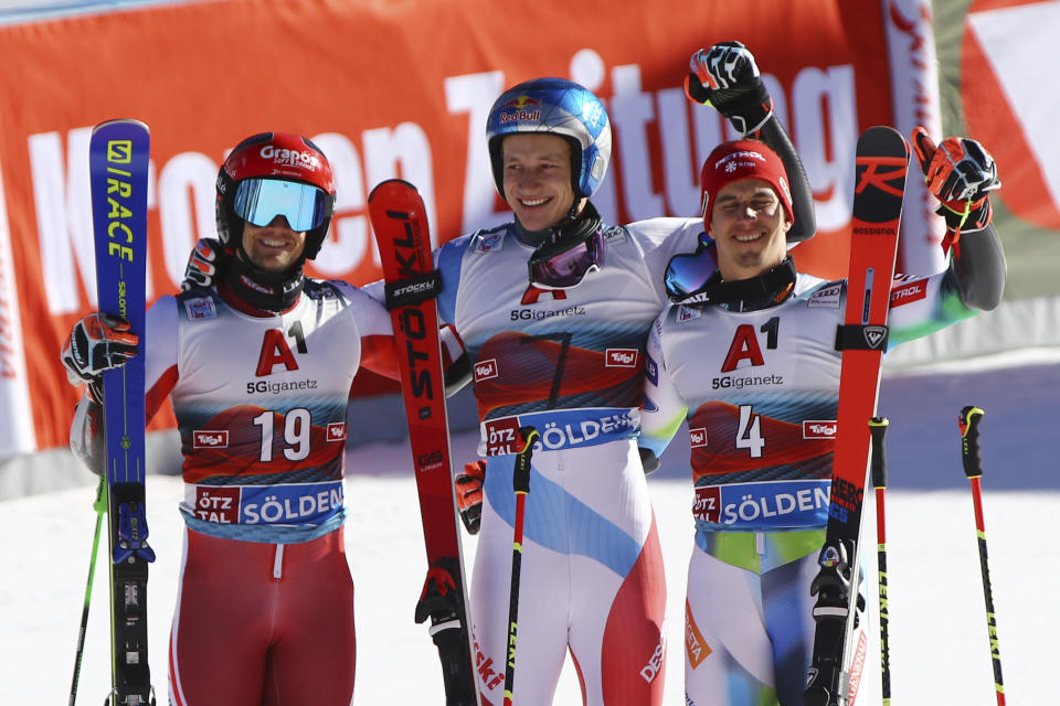Winner Switzerland's Marco Odermatt, center, is flanked by second placed Austria's Roland Leitinger, left and Slovenia's Zan Kranjec on the podium after an alpine ski, men's World Cup giant slalom, in Soelden, Austria, Sunday, Oct. 24, 2021. (AP Photo/Marco Trovati)