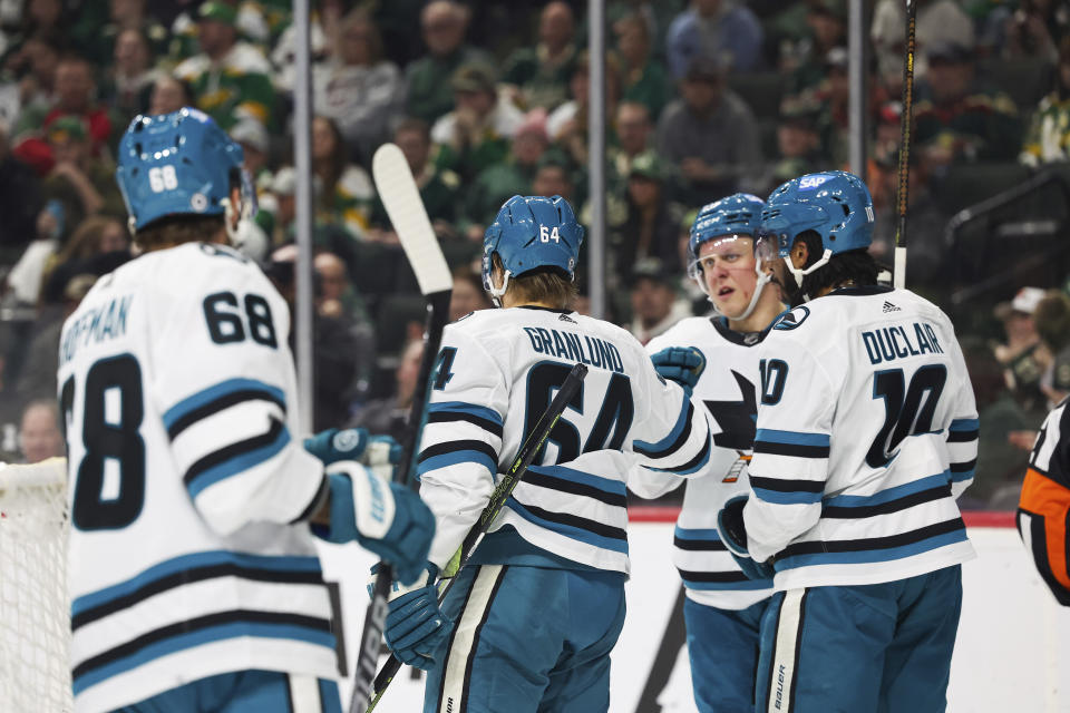 San Jose Sharks center Mikael Granlund (64) high-fives teammates after scoring against the Minnesota Wild during the second period of an NHL hockey game Sunday, March 3, 2024, in St. Paul, Minn. (AP Photo/Stacy Bengs)