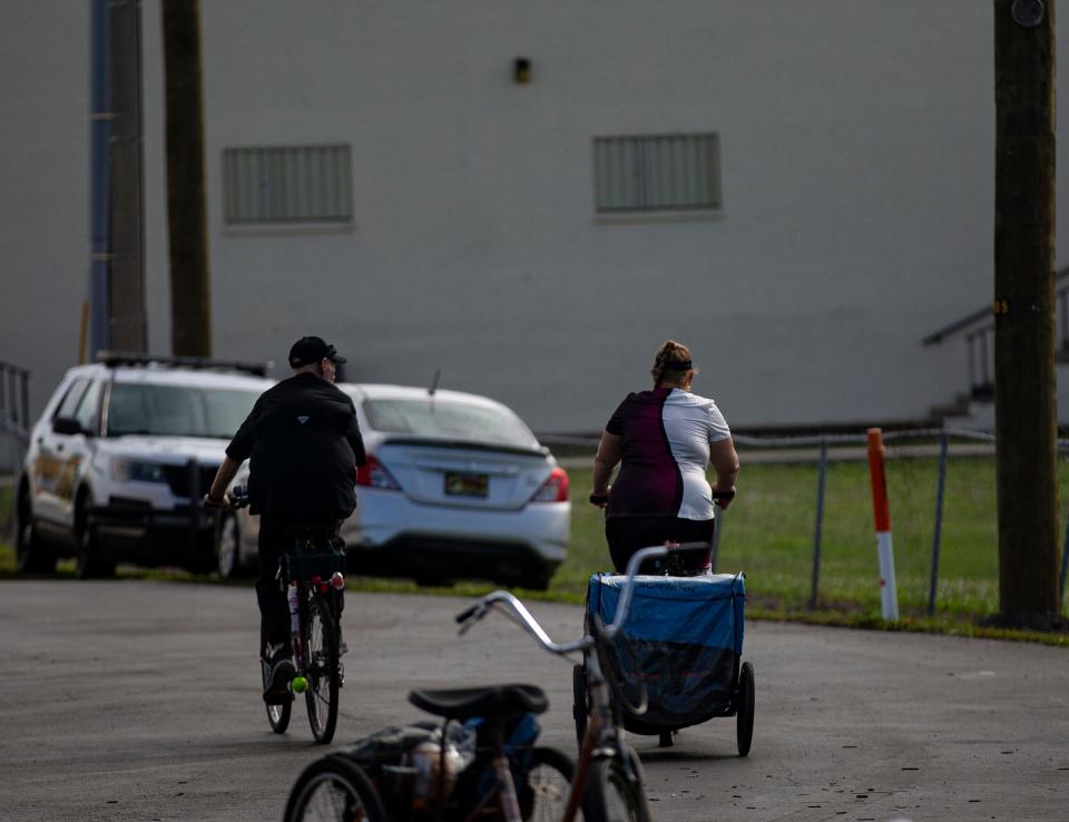 A couple cycles away from the Collier County Hunger and Homeless CoalitionÕs annual "point in time" homeless count at Gulf Gate Plaza in Naples on Friday, Jan. 26, 2024. Vendors were set up at the event to help the homeless which included, food, hygiene kits, clothes and other help.