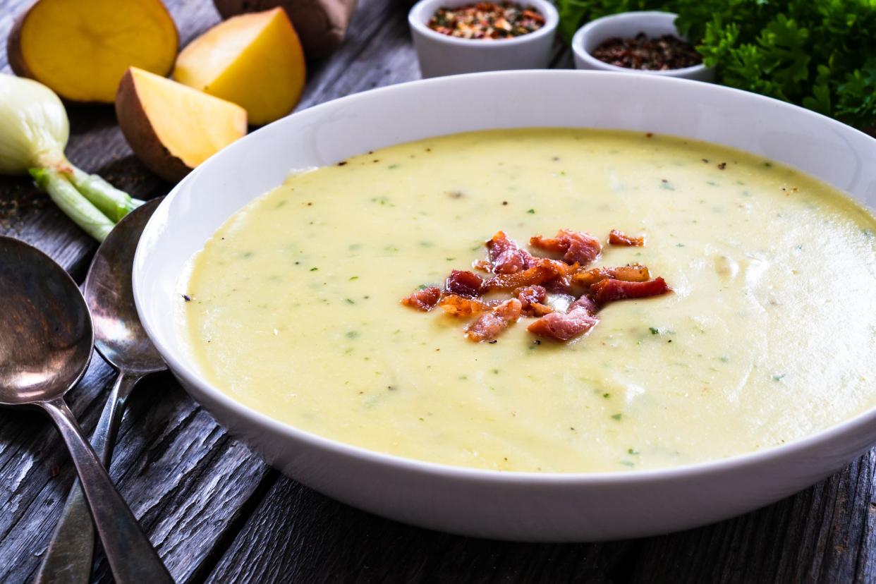 Cream potato soup with bacon on wooden table