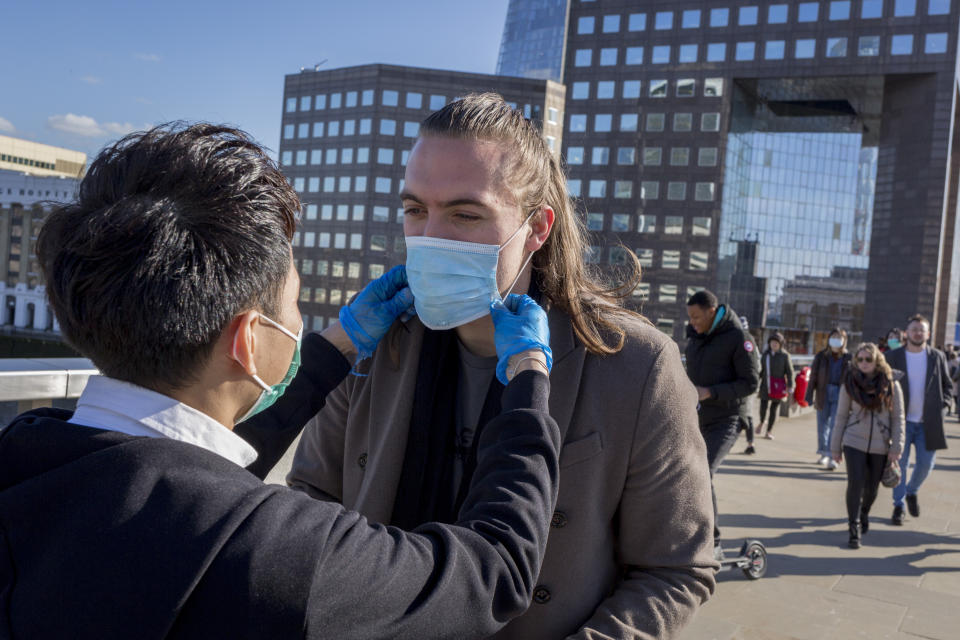 As the UK government lead by Prime Minister Boris Johnson urges Britons to avoid non-essential travel to EU countries, and to avoind contact with others in public places like pubs and theatres during the Coronavirus pandemic, Malaysians wearing their own surgical masks hand out free masks to commuters on London Bridge, on 16th March 2020, in London, England. Within 45mins they had given out 1,000 to passing Londoners. (Photo by Richard Baker / In Pictures via Getty Images)