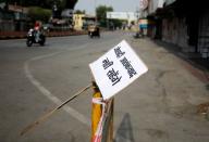 FILE PHOTO: A placard reading "Will not tolerate jihadi terrorism" is tied to a barrier in a deserted road during restrictions imposed by authorities after the death of Kanhaiyalal Teli, in Udaipur