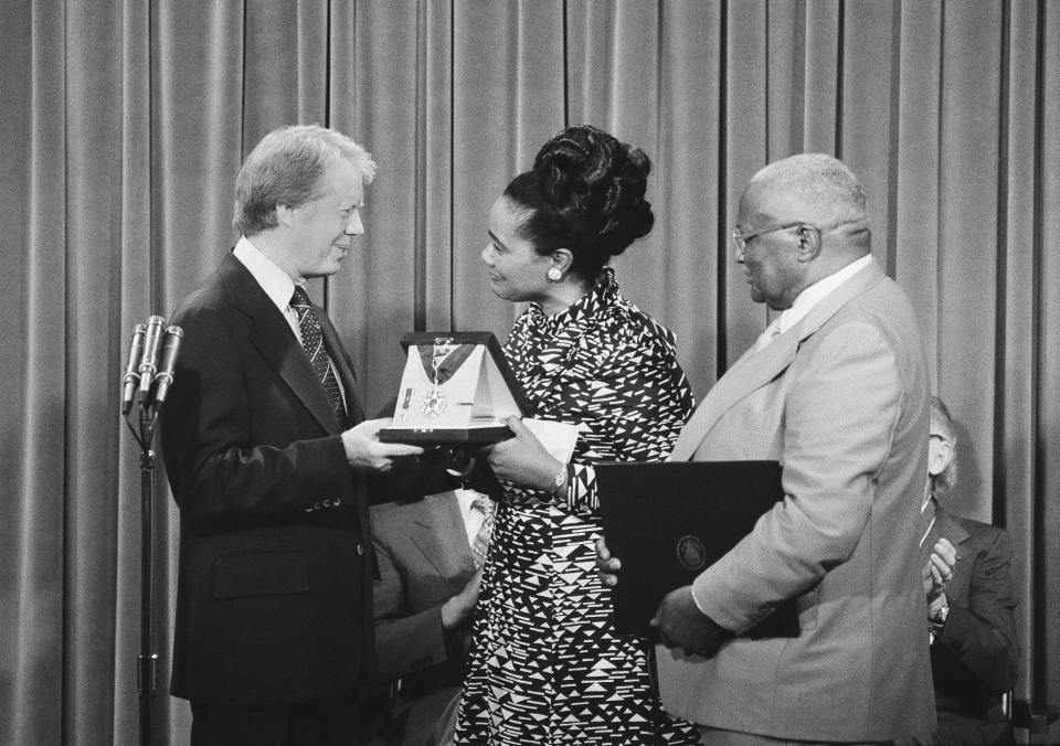 FILE - President Jimmy Carter, left, presents the Medal of Freedom Award to Coretta King, wife of the late Martin Luther King Jr., during a ceremony at the White House in Washington on Monday, July 13, 1977. Referring to the late Dr. King, the inscription on the award states that King "was the conscience of his generation." At right is Martin Luther King, Sr., father of the slain civil rights leader. (AP Photo/John Duricka, File)