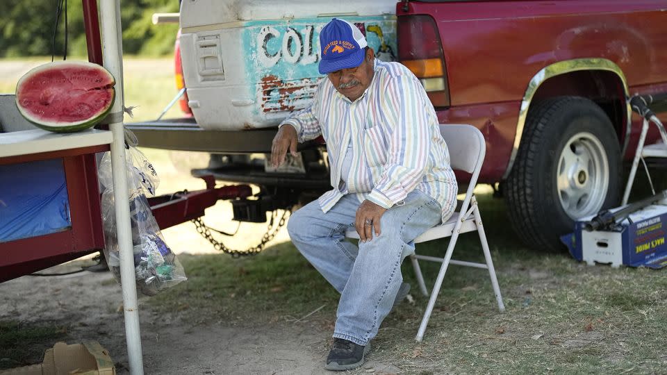 Andres Matamoros sits in the shade as he tries to keep cool while selling fresh fruit and cold coconuts Wednesday, June 28, 2023, in Houston.  - David J. Phillip/AP