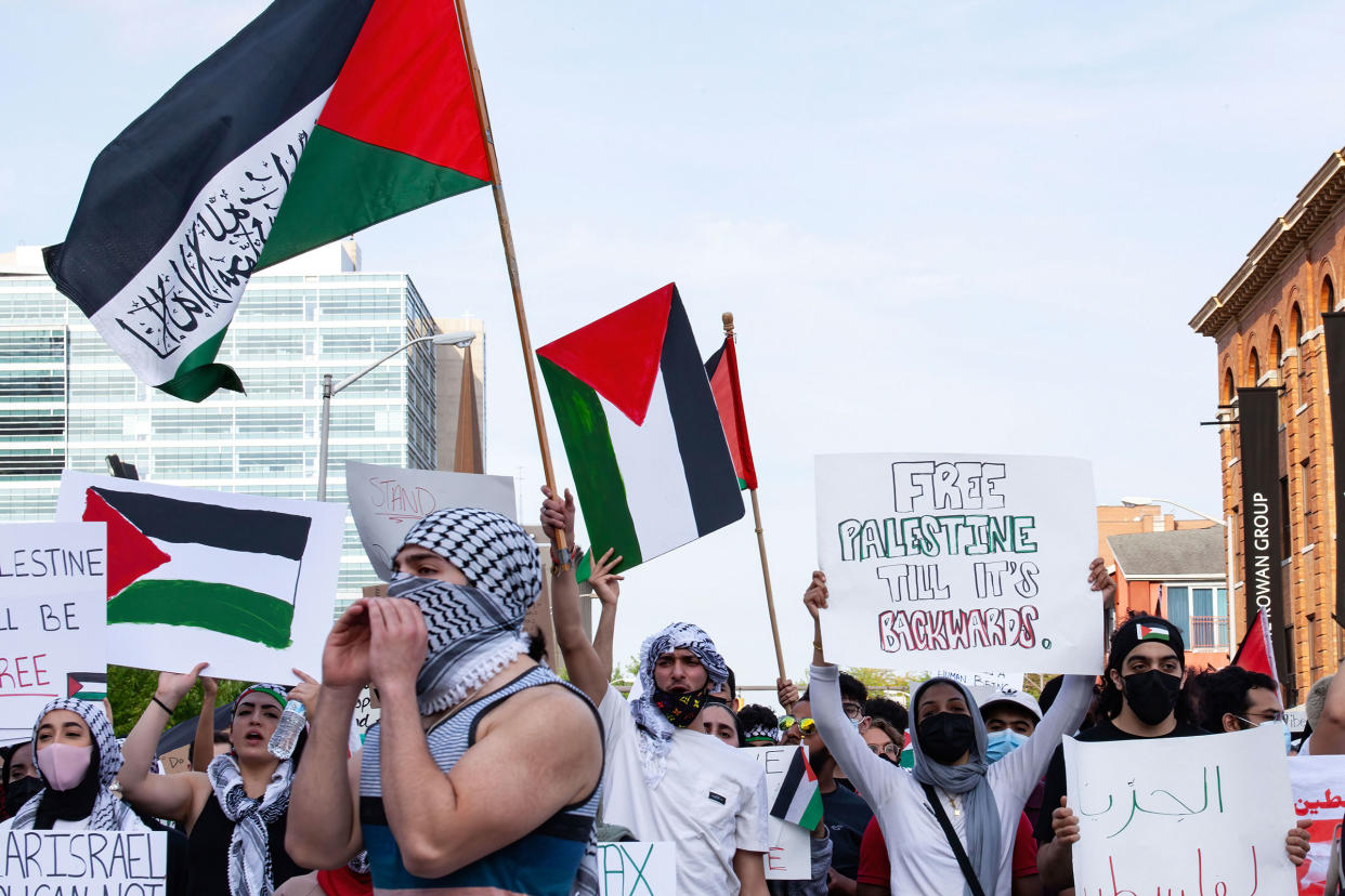 Demonstrators chant slogans while holding flags during the