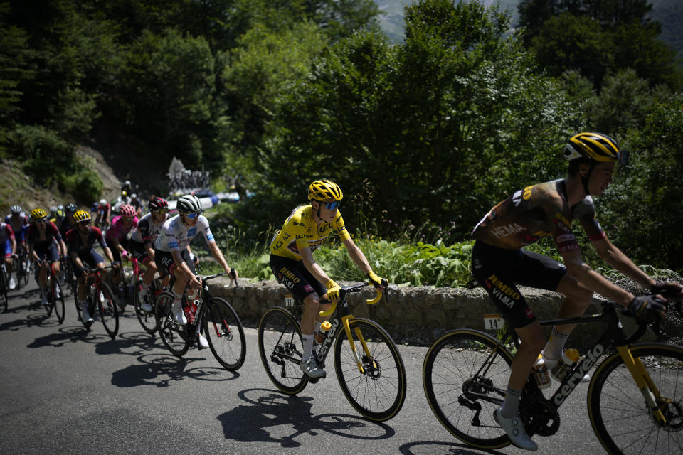 Sepp Kuss of the U.S., right, sets the pace for Denmark's Jonas Vingegaard, wearing the overall leader's yellow jersey, as Slovenia's Tadej Pogacar, wearing the best young rider's white jersey, follows as they climb Col d'Aubisque pass during the eighteenth stage of the Tour de France cycling race over 143.5 kilometers (89.2 miles) with start in Lourdes and finish in Hautacam, France, Thursday, July 21, 2022. (AP Photo/Daniel Cole)