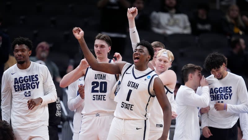 Utah State forward Great Osobor (1) celebrates with teammates at the end of a first-round college basketball game against TCU in the NCAA Tournament, Friday, March 22, 2024, in Indianapolis. Utah State won 88-72.