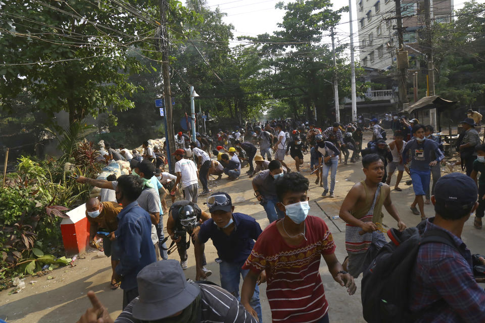 FILE - In this March 28 2021, file photo, anti-coup protesters disperse as the protesters confront police in Yangon, Myanmar. Political turmoil and disruptions following the coup in Myanmar could undo years of progress and double the number of its people living in poverty to nearly half the population, a United Nations report said Friday, April 30, 2021. (AP Photo/File)