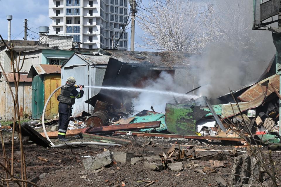 A firefighter extinguishes a fire at the site of a missile strike in the center of Kharkiv, Ukraine, on April 7, 2024.