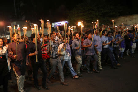 Demonstrators hold torches in a protest against the attack on prominent Bangladeshi writer Muhammed Zafar Iqbal, in Dhaka, Bangladesh, March 3, 2018. REUTERS/Mohammad Ponir Hossain